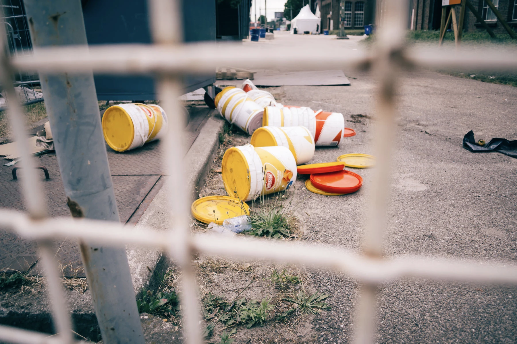 Photo of empty buckets taken from behind a fence.