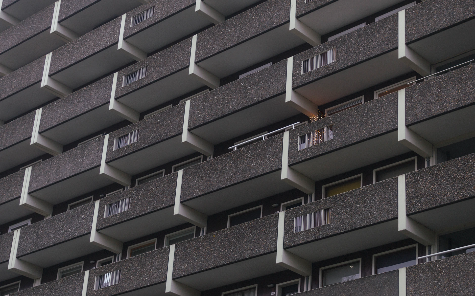 Photo of an apartment building in Amsterdam Noord. One balcony has christmas lights.
