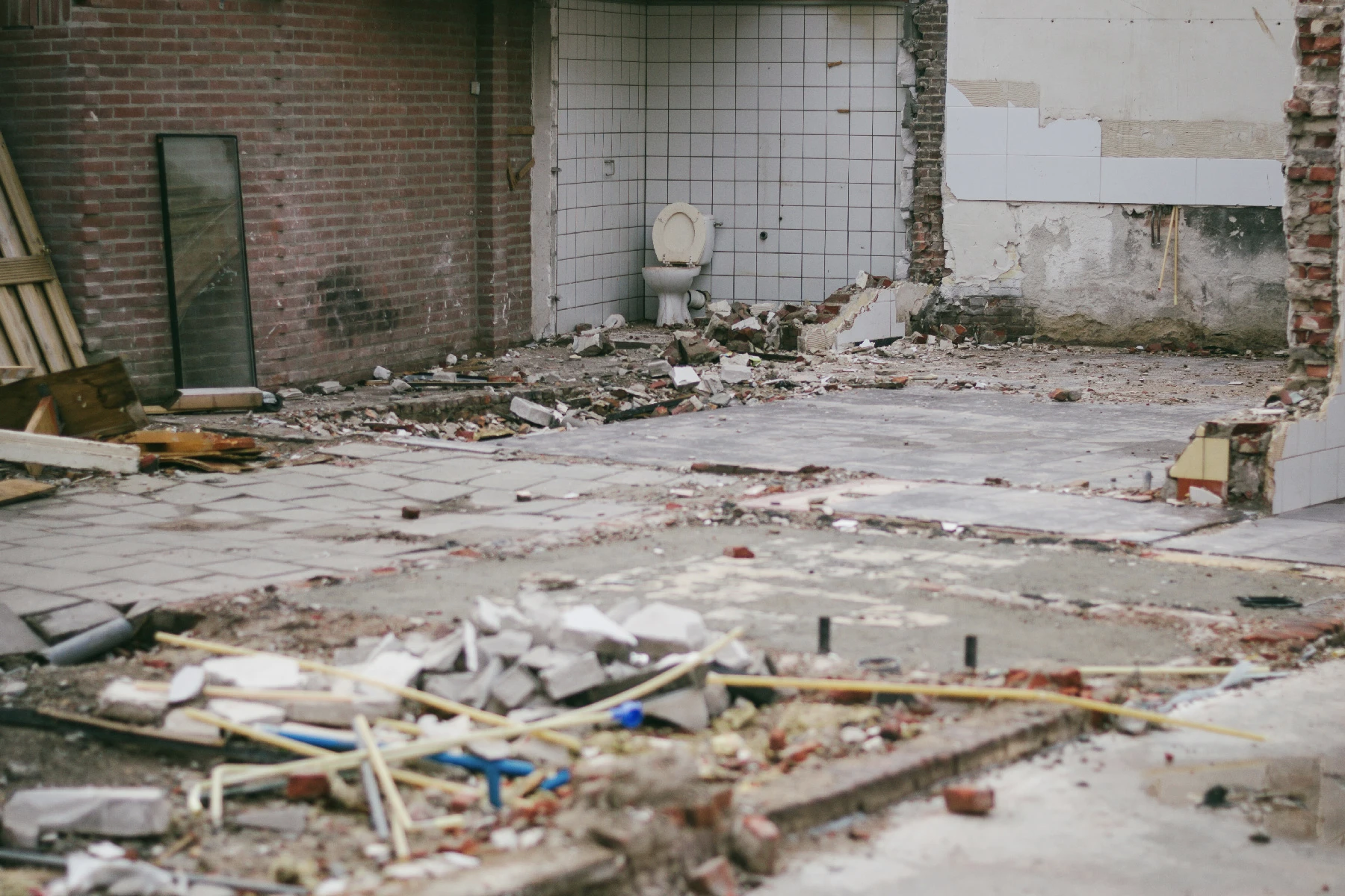 Photo of a building being torn down with the toilet still in it.